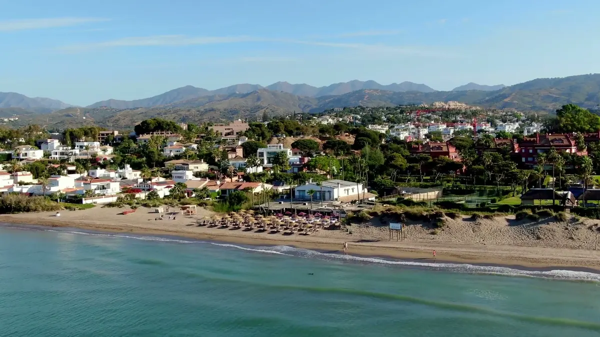 Aerial view of The Beach House on the beach at Marbella with the Sierra Blanca mountains behind