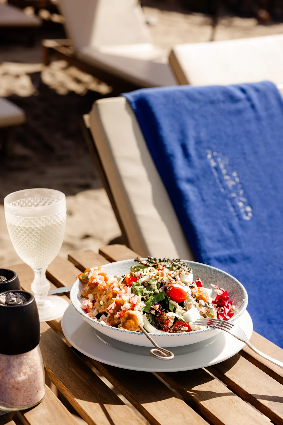 A colourful bowl served on a sun bed side table