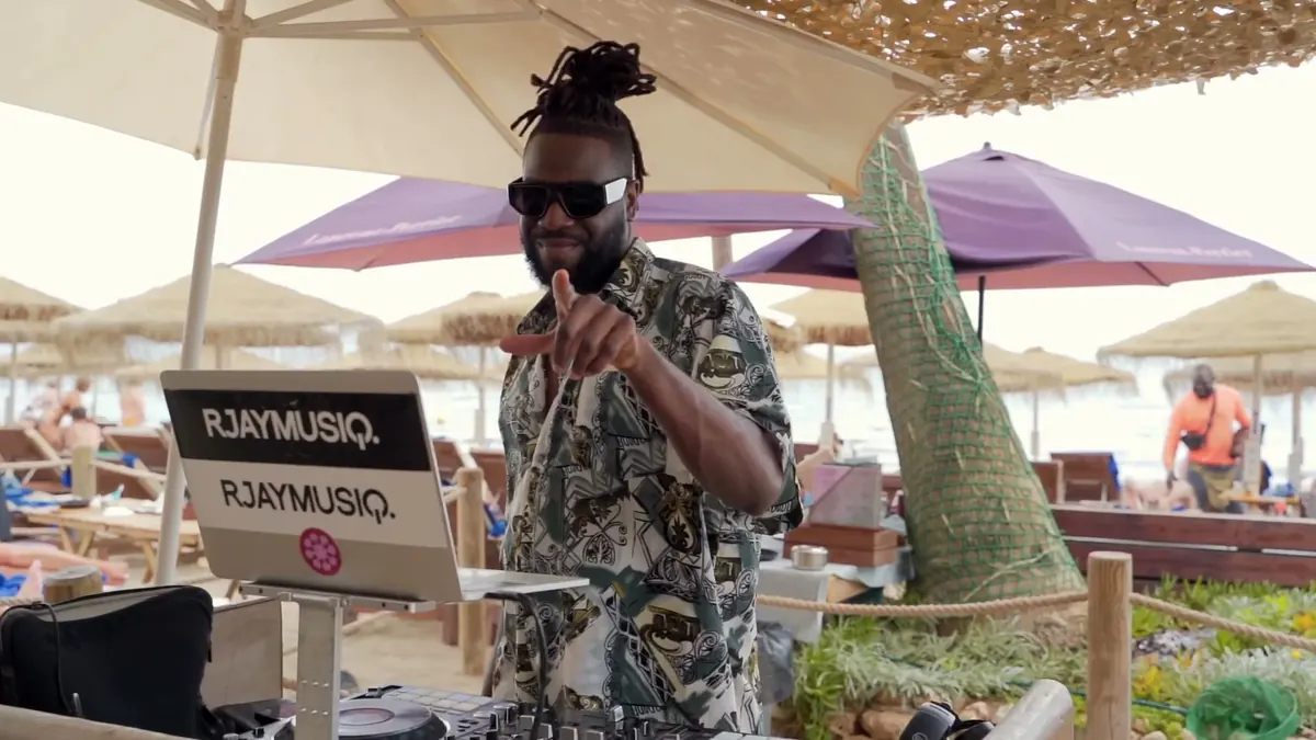 A DJ playing beneath the umbrellas at the beach club