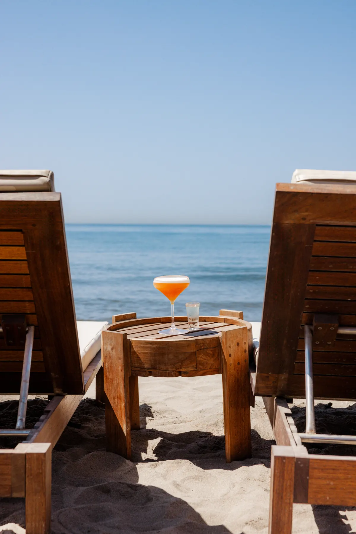 A cocktail between two loungers looking out to sea