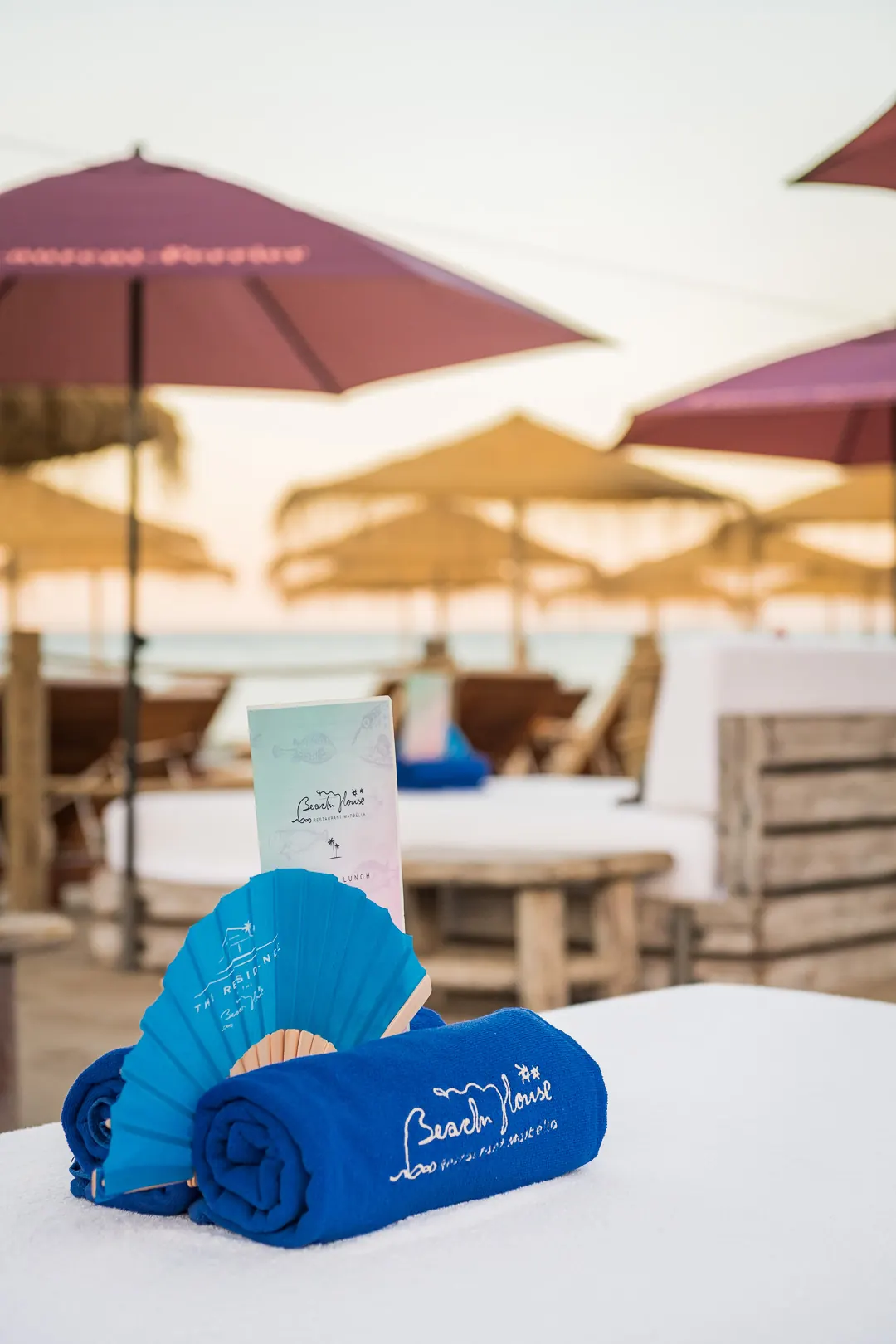 Rolled Beach House towels on a cabana bed