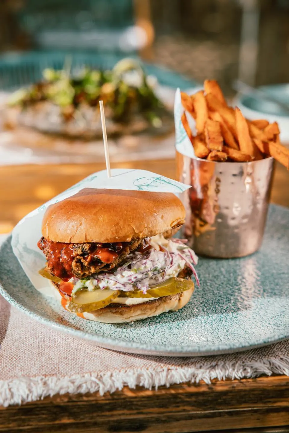 A burger with fries in a copper cup