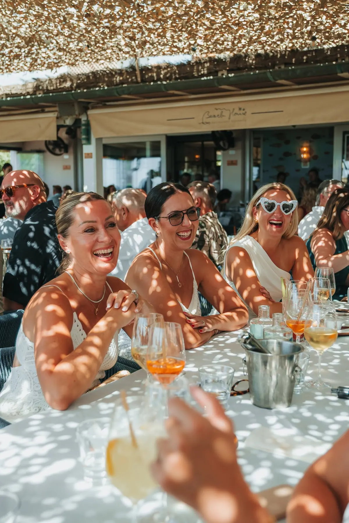 Friends laughing together at a long lunch table