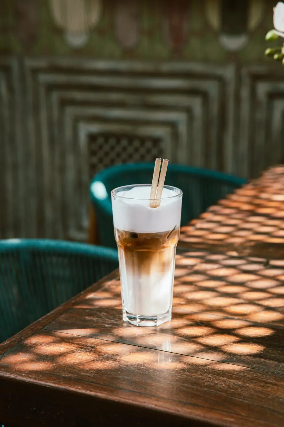 An iced latte on a dappled timber table