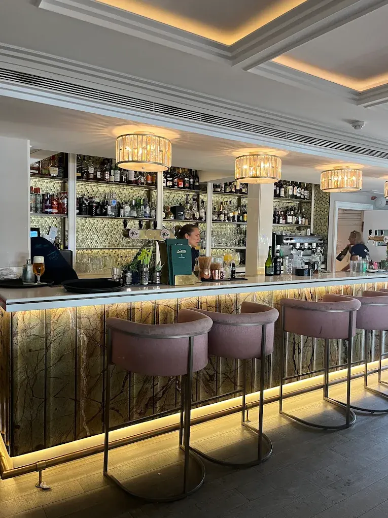 The interior bar with crystal chandeliers and blush velvet bar stools