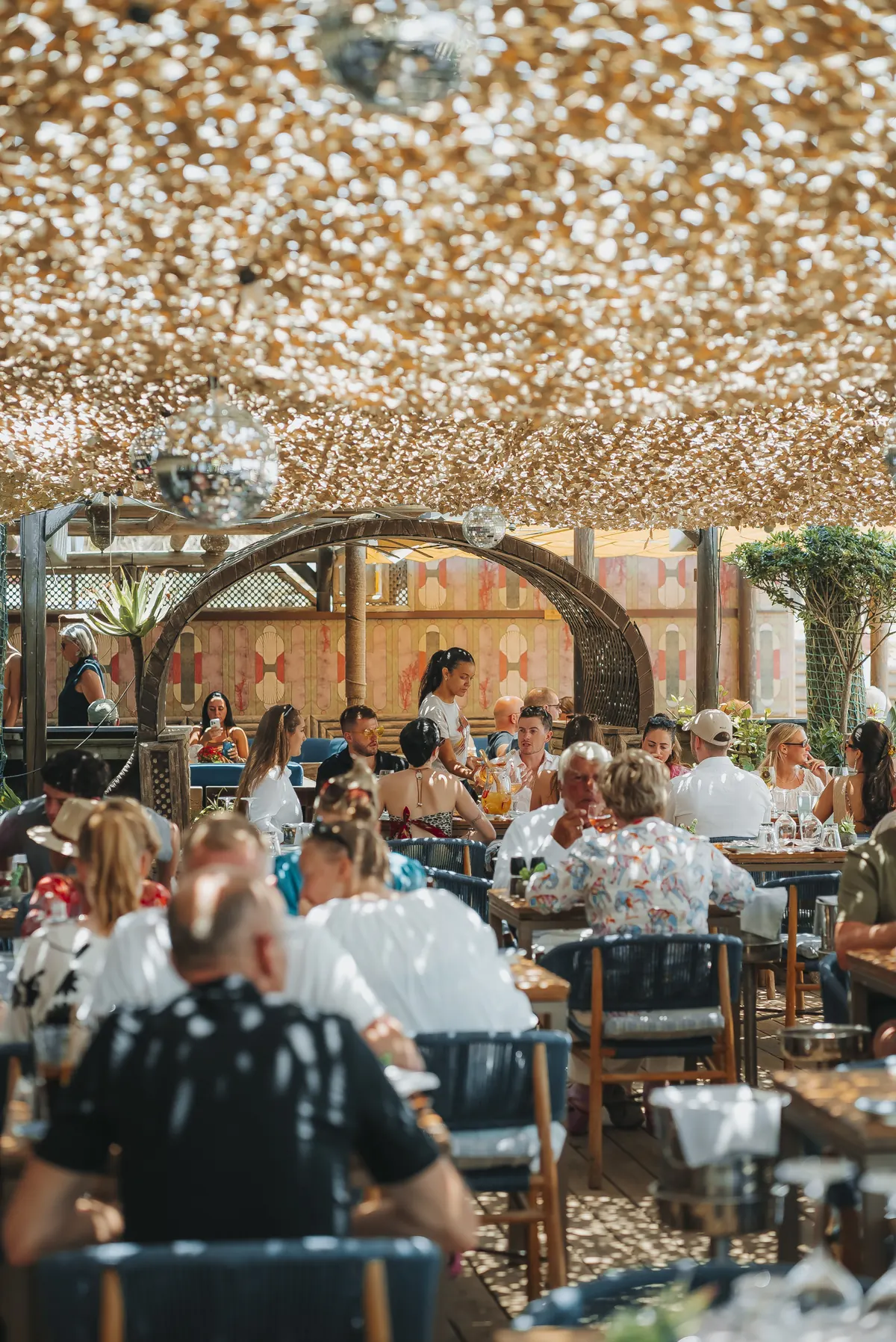 A full terrace of guests beneath the lattice canopy