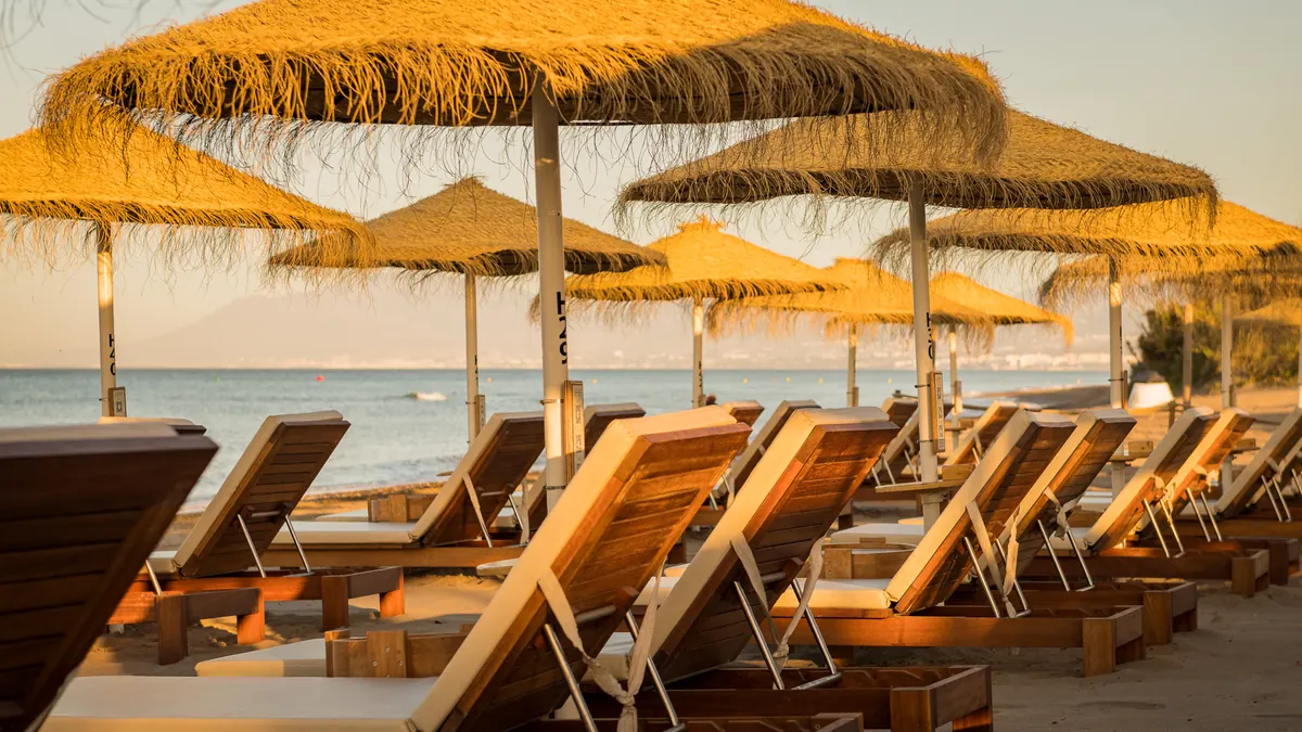 Sun beds and palapas in warm late-afternoon light